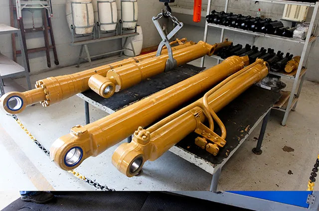 Cilindros hidráulicos amarelos recém-pintados alinhados na bancada da expedição