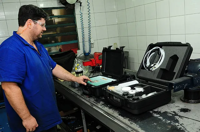 Contador de partículas na maleta aberta sobre a bancada, durante a coleta da amostra de óleo