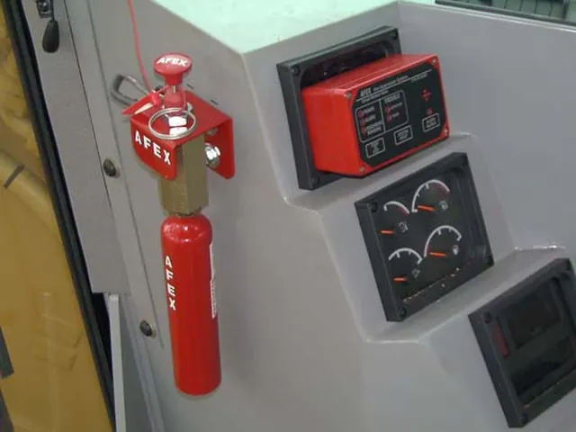 Painel de comando AFEX instalado na cabine, com o acionador manual vermelho e os instrumentos ao lado