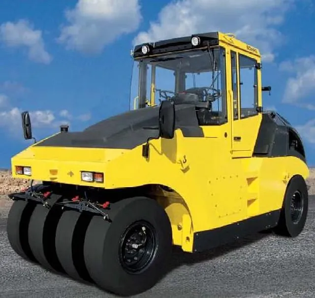 Rolo compactador de pneus amarelo, parado, visto de frente