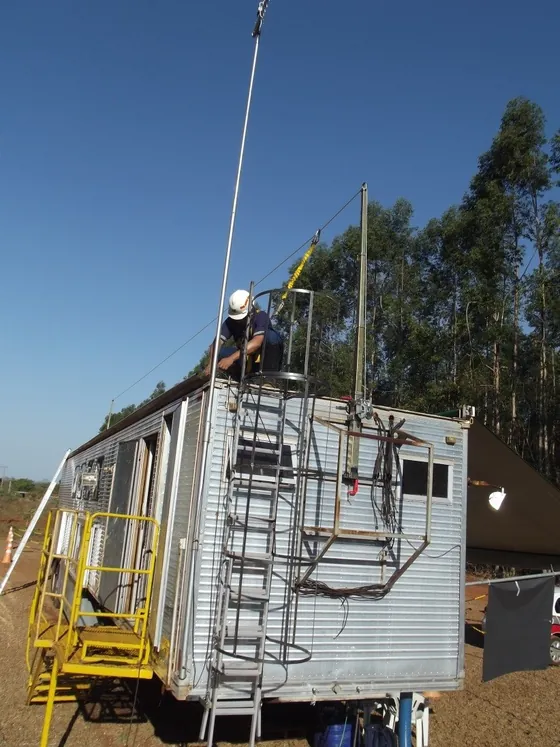 Haste telescópica estendida sobre carreta, com o trabalhador ancorado no alto